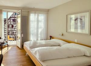 巴塞尔Hotel Rössli的一间带一张白色大床的卧室和一个阳台