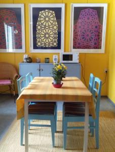 曼塔Art House & Sculpture Garden的餐桌、椅子和墙上的绘画