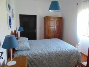 维埃拉·多米尼奥Casa de Granito Charmosa的一间卧室配有一张床、两盏灯和一个梳妆台