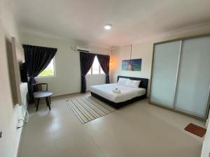 迪沙鲁Tiara Desaru Resort的一间卧室设有一张床和一个大窗户