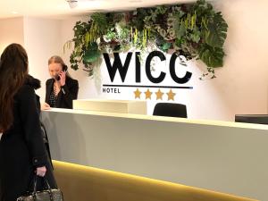 瓦赫宁根Hotel WICC的一位妇女在签证接待处用手机交谈
