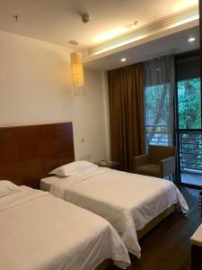 广州广州纺园公寓酒店的酒店客房,配有两张床和椅子