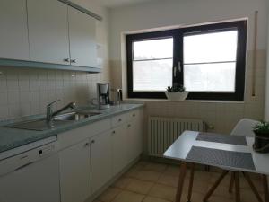 KreuzwertheimFeWo mit Burgblick的厨房设有水槽、窗户和桌子