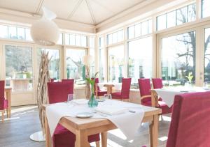 明辛奥贝姆巴赫城堡拜尔酒店的用餐室设有桌椅和窗户。
