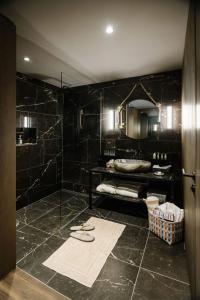 格林德尔瓦尔德Bergwelt Grindelwald - Alpine Design Resort的带淋浴和黑色大理石墙壁的浴室