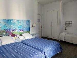 隆达隆达波罗酒店的一间卧室设有两张床,墙上挂着一幅画