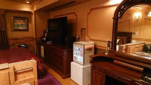 川口市Hotel Zips (Adult Only)的一间配有电视的房间和一间配有床的房间