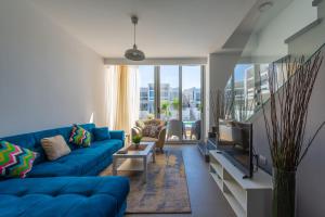 赫尔格达VESTA - El Gouna Residence的客厅配有蓝色的沙发和电视