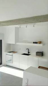 KrokosAESIS的白色的厨房配有白色橱柜和水槽