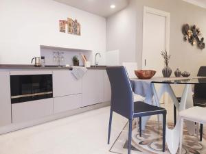 韦尔纳扎Vernazza Luxury Apartment的厨房配有白色橱柜和桌椅