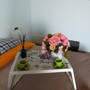 San CalogeroIl colle degli ulivi的床上的桌子,上面有鲜花和杯子