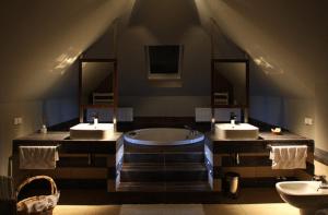 Bronisze里克纳宾馆的大型浴室设有两个盥洗盆和浴缸。