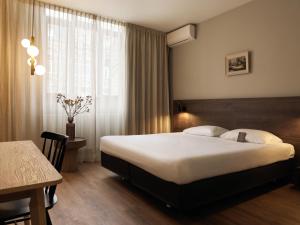 马斯特里赫特Townhouse Apartments Maastricht的一间卧室配有一张床、一张桌子和一个窗户。