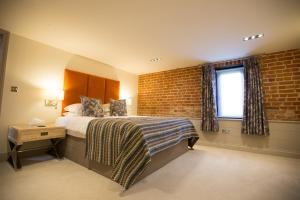 切姆Channels Retreat的一间卧室设有一张床和砖墙