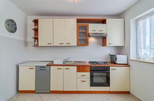拉巴克Seaview Apartment Bojan Rabac的厨房配有白色橱柜和水槽