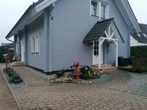 SehlenFerienwohnung“puutalossa“的蓝色的房子,设有门廊和庭院