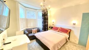 伦敦Modern and cosy studio flat的一间卧室配有一张床、一张沙发和窗户。