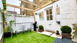 伦敦Modern and cosy studio flat的一个带草坪和白色房子的小后院