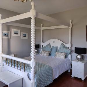 基尔Stella Maris Luxury Bed and Breakfast的卧室配有白色天蓬床和蓝色枕头