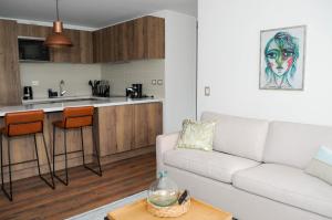 圣地亚哥Apartment - Kennedy - Parque Arauco的一间带白色沙发的客厅和一间厨房