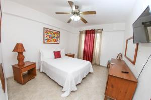 圣多明各阿库埃里姆套房度假酒店的一间卧室配有一张床和吊扇