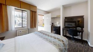 基洛纳休憩套房酒店的酒店客房配有一张床、一张书桌和一台电视。