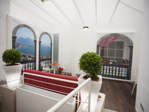 那不勒斯纳博拉尔特酒店的阳台设有红色长椅,享有城市美景。