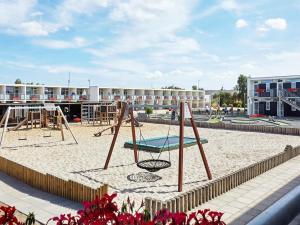 格莱斯堡5 person holiday home on a holiday park in Glesborg的一个带秋千的沙地游乐场