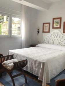 塞埃Casa Divina Elías Sixto Pampín的卧室配有白色的床和2把椅子