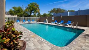 坦帕坦帕贝斯特韦斯特酒店的一个带蓝色躺椅的游泳池和一个游泳池