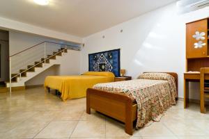 埃里切圣库苏马诺开放式空间公寓的酒店客房带两张床和楼梯