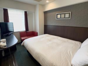 名古屋名古屋荣微笑酒店的酒店客房配有一张床、一张书桌和一台电视。