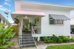 Cairns NorthTropicana Bungalow - Retro Getaway的白色房子,有粉红色遮阳篷