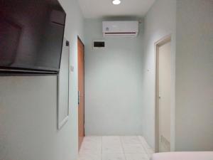 雅加达Pondok Indah24 Hotel的客房设有带炉灶和冰箱的走廊。