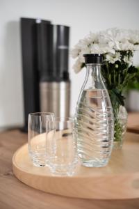 奥尔登堡Schöner wohnen im Herzen Oldenburgs的桌子上放着两杯玻璃和花瓶
