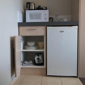 凯库拉凯库拉贝拉维斯特酒店的厨房配有白色冰箱和微波炉