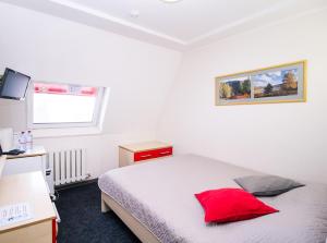 别洛库里哈布拉格达酒店的一间卧室配有一张红色枕头的床