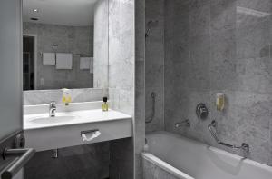 韦尔斯普罗波格酒店的一间带水槽、浴缸和淋浴的浴室