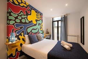 圣塞瓦斯蒂安Off Beat Guesthouse - Self-check-in - Sleep Conscious的一间卧室设有一张大床和色彩缤纷的墙壁