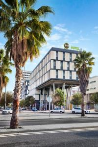 马塔罗B&B HOTEL Barcelona Mataro的街道前有棕榈树的酒店