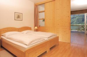 卡尔达罗Residence Haus Kaltersee的一间卧室设有一张床和一个大窗户
