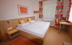 普法尔韦尔芬沃卡里奥旅馆的一间小卧室,配有一张床和一张书桌