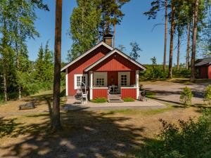 HirsjärviHoliday Home Sepelkyyhky by Interhome的树林里的一个红白的棚子