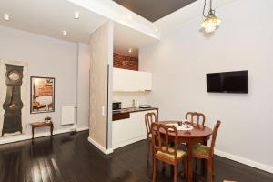 罗兹Apartament Patisserie by Good Time的厨房以及带桌子和时钟的用餐室。