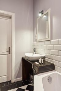 罗兹Apartament Patisserie by Good Time的带浴缸、水槽和镜子的浴室