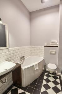 罗兹Apartament Patisserie by Good Time的带浴缸、卫生间和盥洗盆的浴室