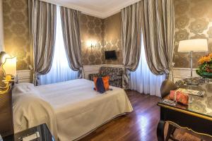 罗马阿尔伯格戴尔萨纳托酒店的一间卧室配有一张床、一把椅子和一张桌子