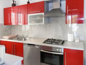 鲁巴达Holiday Home Bernardi by Interhome的厨房配有红色橱柜和不锈钢炉灶
