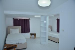 锡德Aquarius Hotel的小房间设有两张床和一盏灯