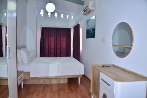 锡德Aquarius Hotel的卧室配有白色的床和镜子